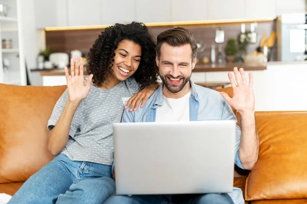 Koltukta dizüstü bilgisayarı olan çok ırklı bir çift.