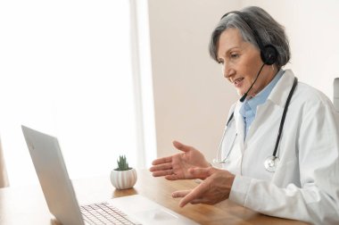 Kıdemli bayan doktor ofisinde oturuyor.