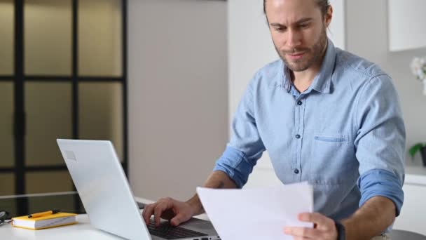 Ein Hipster-Typ benutzt einen Laptop drinnen — Stockvideo