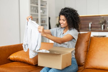 Afro-Amerikalı kadın paket kutusunu açıyor.