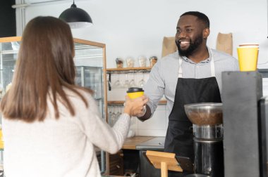 Afrikalı bir garson misafirine servis yapıyor.