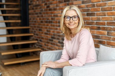 Neşeli, olgun sarışın bir kadının portresi.