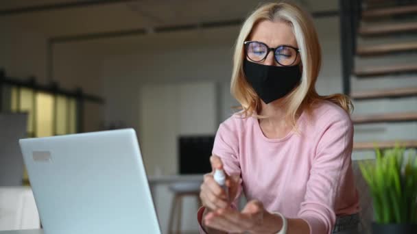 Frau mittleren Alters trägt medizinische Maske — Stockvideo