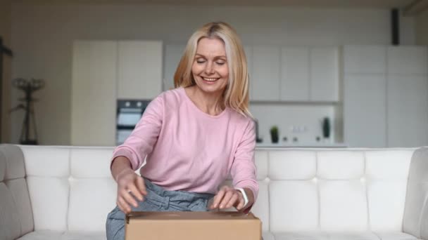 Woman unpacking box and feels sad about her wrong order — Stock Video