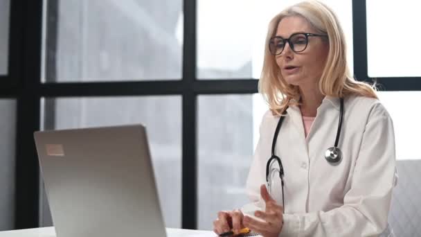 Női orvos köpeny beszél beteg online — Stock videók