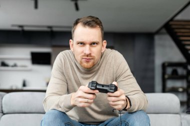 Video oyunu oynayan yakışıklı sakallı adam.