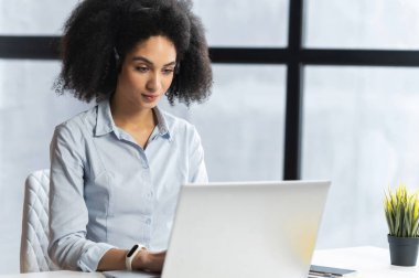 Bilgisayarda kulaklığı olan güzel genç bir kadın.