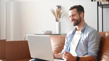 Genç bir sakallı adam video görüşmesi için dizüstü bilgisayar kullanıyor.