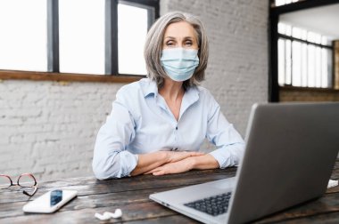 Yüzü maskeli yaşlı kadın içeride.