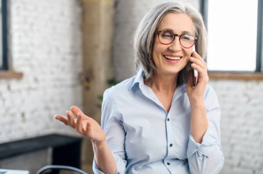 Kıdemli kadın telefon görüşmesi yapıyor. 