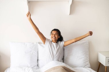 Genç melez bir kadın uyanıyor ve esniyor.