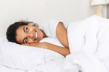 Yumuşak battaniyeyle örtülmüş melez bir kadın.