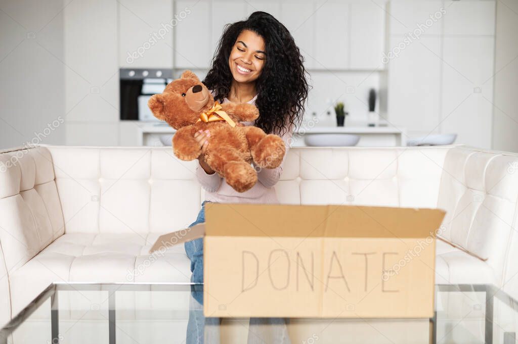 Mixed-race woman with donation box and teddy bear