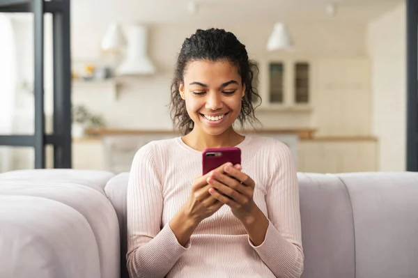 Mladá latinská žena chatuje u telefonu a usmívá se — Stock fotografie