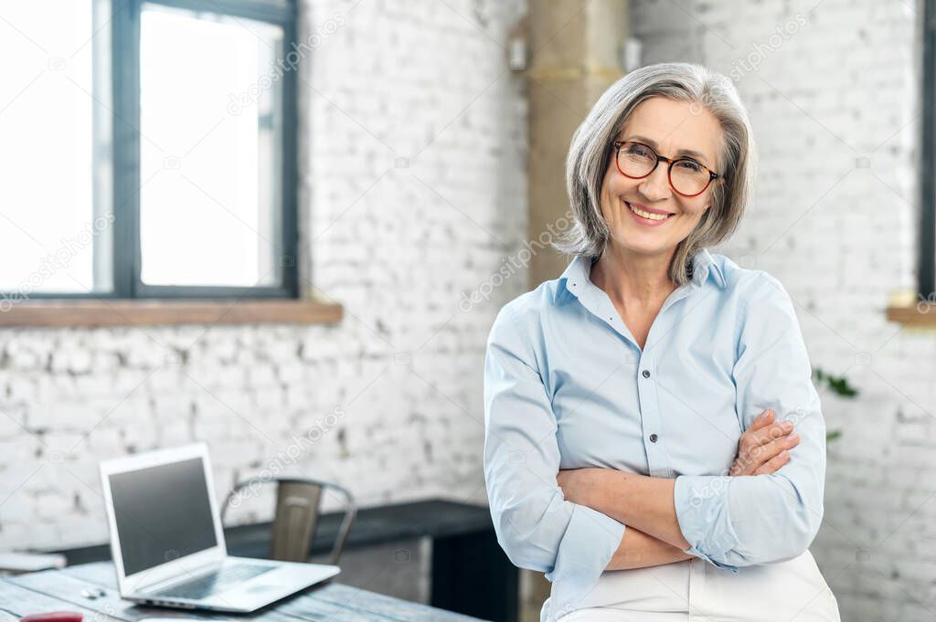 Positive businesswoman standing with arms folded