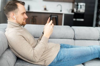 Nazik Avrupalı adam telefona bakıyor ve gülümsüyor.