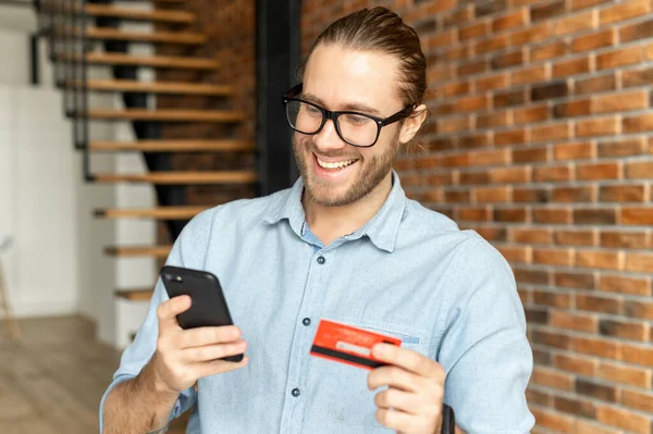 Smiling young businessman paying by credit card