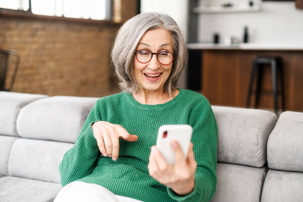 Mature senior woman using a smartphone at home