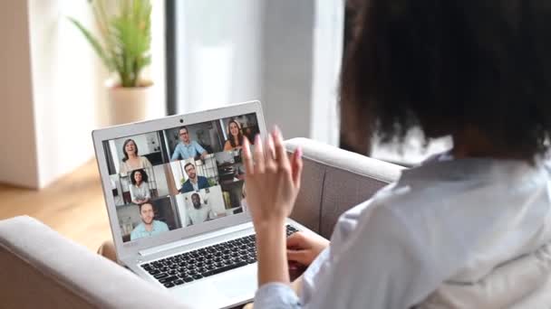 Çift ırklı genç bir kadın içeride video bağlantısı için laptop kullanıyor. — Stok video