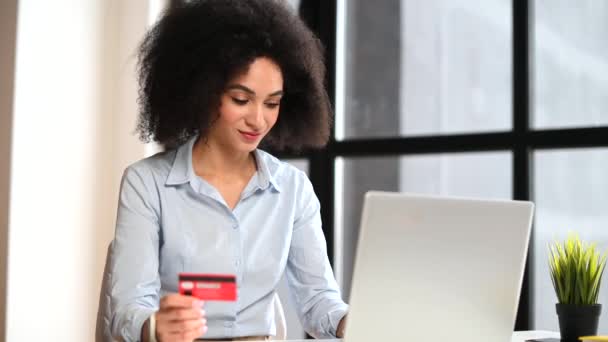 Uma jovem mulher biracial está usando um laptop indoor — Vídeo de Stock