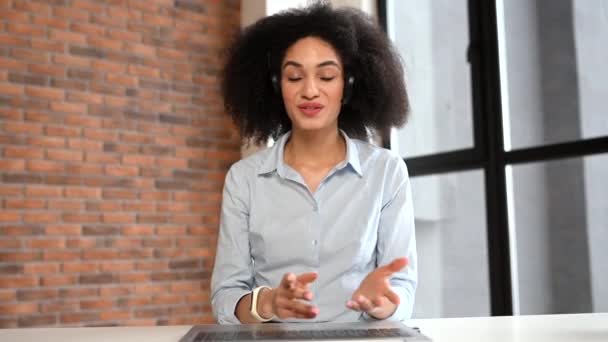 Vídeo chat com uma mulher afro-americana amigável usando fone de ouvido — Vídeo de Stock