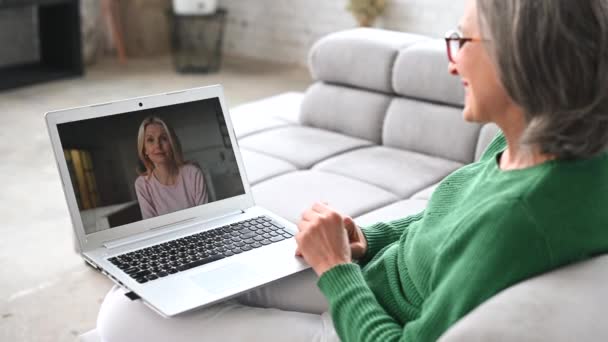 Mature senior woman is using a laptop at home — Stock Video