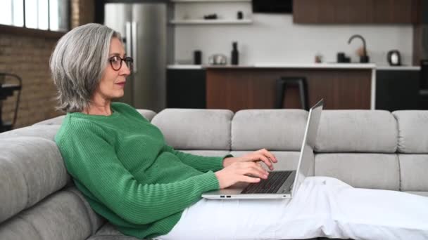 上了年纪的女人在家里用笔记本电脑 — 图库视频影像