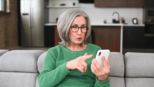 Mature femme âgée utilise un smartphone à la maison — Video