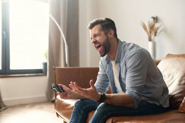 Genç erkek bağımlı oyuncu bağırıyor.