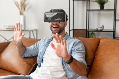 Sanal gerçeklik gözlüğü takan mutlu genç sakallı hippi.