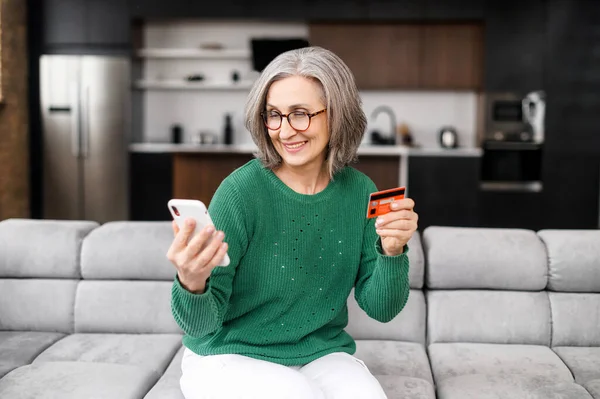 Well-dressed woman on retirement managing family budget and paying the bills by credit card