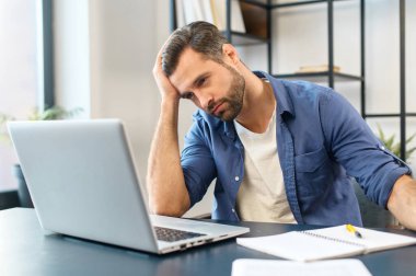 Genç, sakallı, serbest çalışan bir ofis çalışanı.