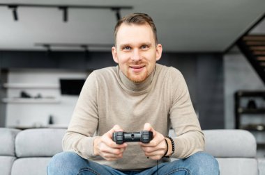 Genç sakallı hippi video oyunları oynuyor.