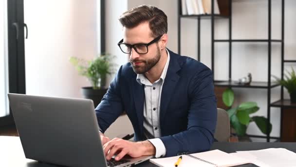 Succesvolle bebaarde jonge zakenman op het werk — Stockvideo