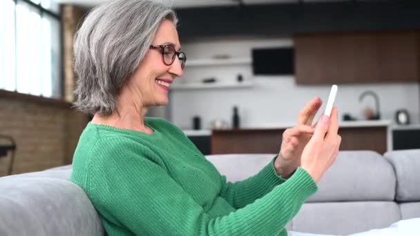 Ältere Seniorin nutzt Smartphone zu Hause — Stockvideo