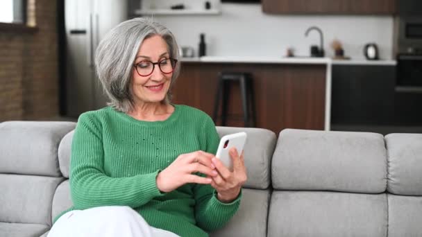 Ältere Seniorin nutzt Smartphone zu Hause — Stockvideo