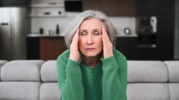 Yaşlı kadın baş ağrısı hisseder. — Stok video