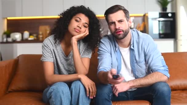 Multiracial couple chilling on the couch, watching movie — Stock Video