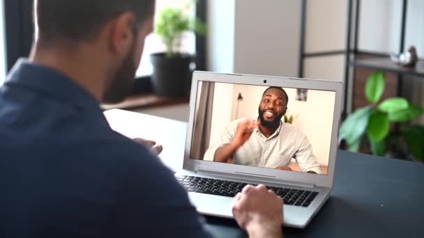Een gefocuste man draagt casual shirt met behulp van een laptop voor videogesprek — Stockvideo