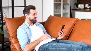 Video görüşmesi için cep telefonu kullanan yakışıklı bir genç.