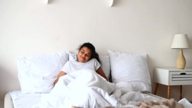 Genç melez bir kadın uyanıyor ve esniyor.