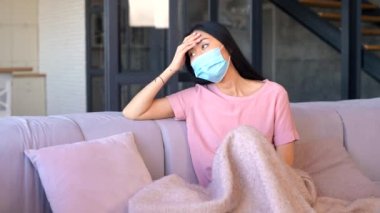 Maske takan genç bir Asyalı kadın evde izole edilmiş.