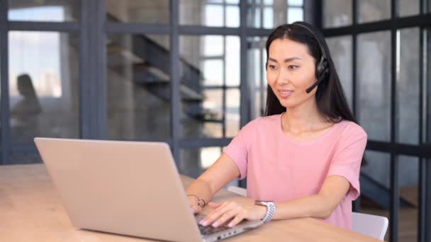 Egy vonzó fiatal ázsiai nő egy laptopot használ videohívásra. — Stock videók