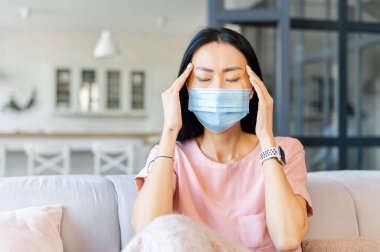Koronavirüs belirtileri gösteren genç bir Asyalı kadın.