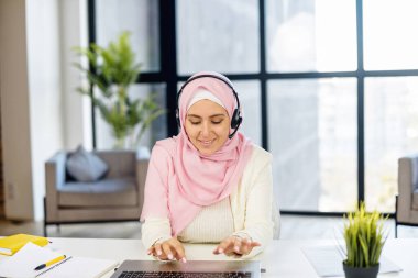 Genç Arap melez kadın kulaklık takıyor.