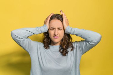 Genç ve çekici bir kadın acıdan muzdarip, sarıda soyutlanmış.