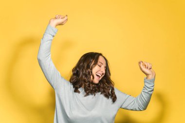 Dans eden genç ve çekici bir kadın, sarıda yalnız.