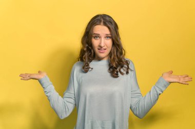 Genç ve çekici bir kadın kollarını açar, sarıda izole bir şekilde.