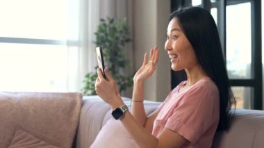 Çekici bir Asyalı kadın video görüşmesi için bir şapka kullanıyor.