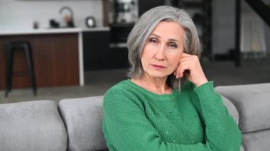 Gri saçlı, gülümseyen yaşlı kadın.